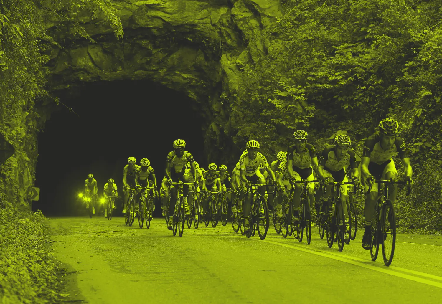 Pelotão do Tour do Rio atravessando um túnel, foto com tratamento em amarelo